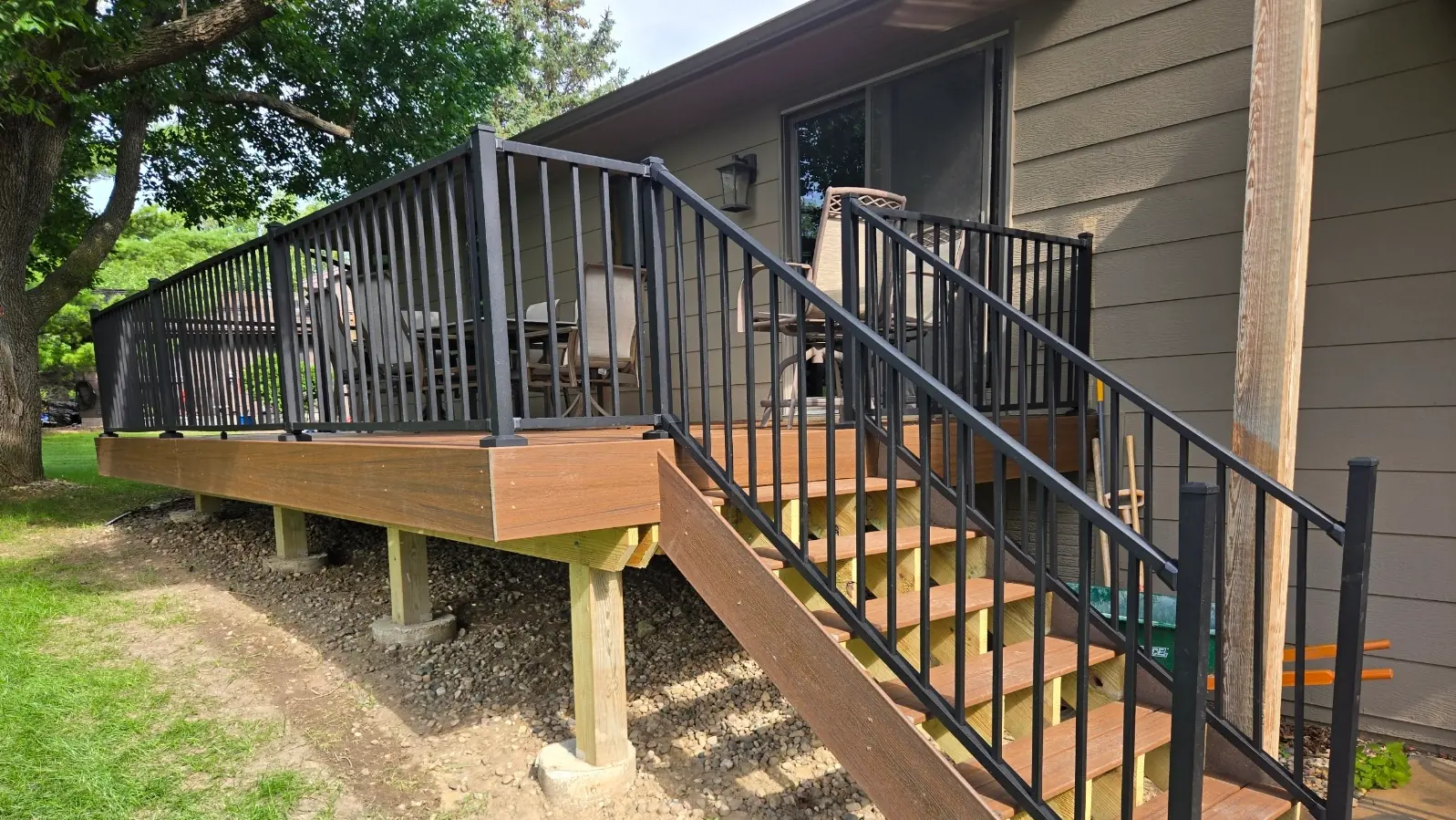 Custom backyard deck with wide steps and railing — cedar finish (after)